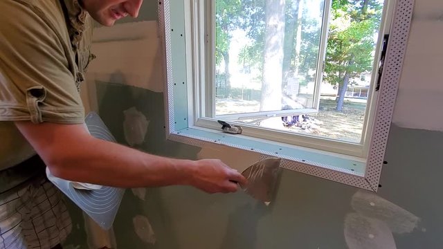 Carpenter spackling window wall 