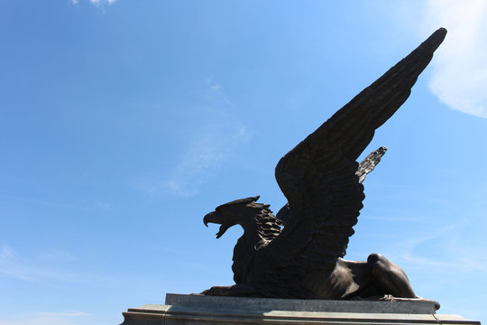 Statue of Griffin or Griffon against the sky. A legendary creature with the body of a lion, the head and wings of an eagle. Ancient mythology fantasy