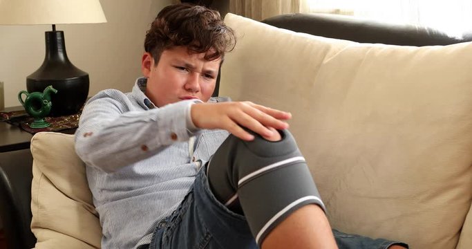 Painful young boy with protective knee brace