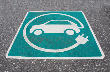 Electric vehicle charging station sign on asphalt in public area