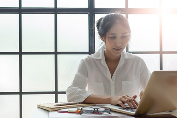 Business woman working on desk office with nature lighting background