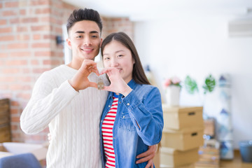 Young asian couple holding keys of new house, smiling happy and excited moving to a new apartment