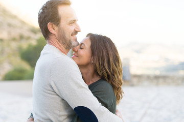 Fototapeta premium Romantic couple smiling, cuddling and hugging on a sunny day