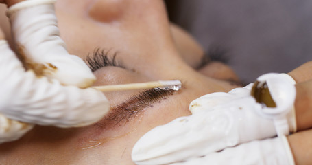 Beautician hands doing eyebrow microblading with ink needle