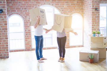 Couple wearing funny cardboard boxes with happy faces, moving to a new house, crazy and creative concept