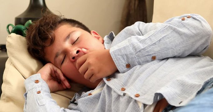 Portrait of a fast asleep young boy lying on sofa