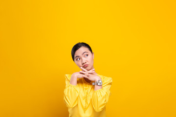 Woman feel confused isolated over yellow background
