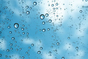 Fototapeta na wymiar Rain on the window, natural skin of the rain The natural form of rainwater on a sky background.
