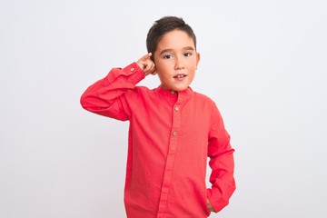Beautiful kid boy wearing elegant red shirt standing over isolated white background smiling doing phone gesture with hand and fingers like talking on the telephone. Communicating concepts.