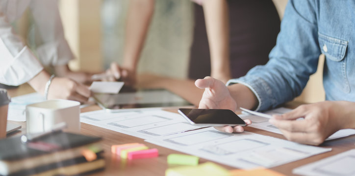 Close-up of UX web developer planing the idea on smartphone application together