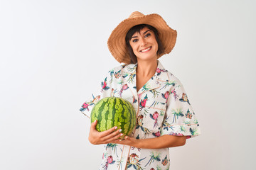 Woman on vacation wearing summer hat holding watermelon over isolated white background with a happy face standing and smiling with a confident smile showing teeth