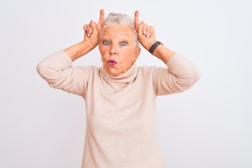 Senior grey-haired woman wearing turtleneck sweater standing over isolated white background doing...