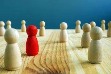 Inclusion social concept. Red figurine between wooden figurines.