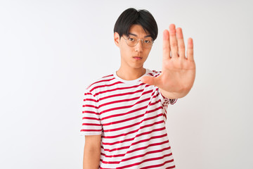Young chinese man wearing glasses and striped t-shirt standing over isolated white background doing...