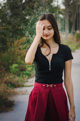 Young beautiful girl with long hair is walking along the street.