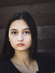 Portrait of a beautiful young girl with dark long hair and black eyes.