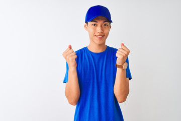 Chinese deliveryman wearing blue t-shirt and cap standing over isolated white background celebrating surprised and amazed for success with arms raised and open eyes. Winner concept.