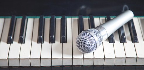   Microphone on piano keyboard. White and black. Music