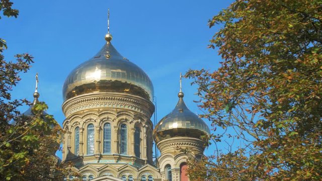 View of orthodox (Russian) St Nicholas Naval Cathedral golden domes and crosses on blue sky in sunny autumn day at Karosta, Liepaja, wide shot