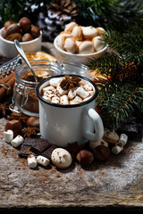 Obraz na płótnie Canvas cup of hot chocolate with marshmallows and sweets on wooden background, vertical