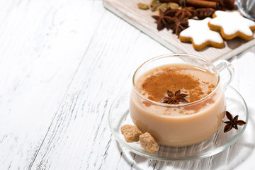 cup of hot spicy masala tea and Christmas cookies on white background