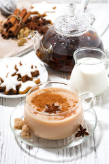 cup of spicy masala tea and Christmas cookies on white background, vertical top view