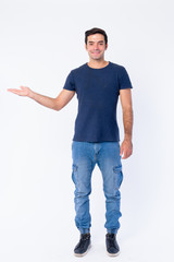 Full body shot of happy young Persian man showing something