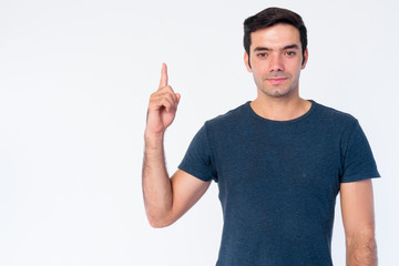 Portrait of young handsome Persian man pointing up