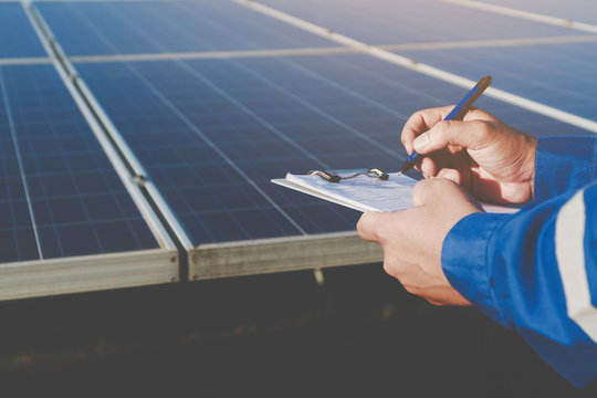 industrial concept; engineer in blue uniform working on repairing generating power of solar power plant