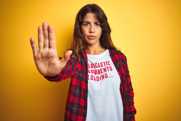 Beautiful woman wearing funny t-shirt with irony comments over isolated yellow background with open...