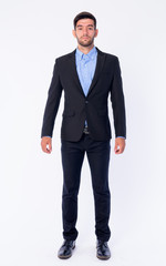 Full body shot of young bearded Persian businessman in suit