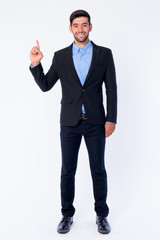 Full body shot of happy young bearded Persian businessman pointing up