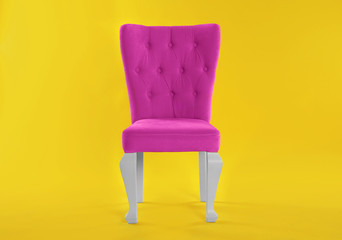 Stylish pink chair on yellow background. Element of interior design