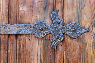 Old wooden door with decorative iron ornament.