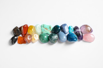 Different beautiful gemstones on white background, top view