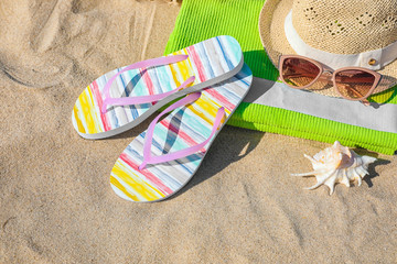 Set with stylish beach accessories on sand, above view