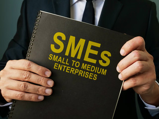 Businessman holds SMEs Small to Medium Enterprises.