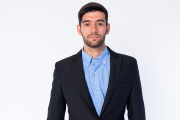 Portrait of young bearded Persian businessman in suit looking at camera