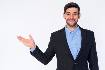 Portrait of happy young bearded Persian businessman showing something