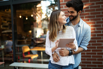 Happy young couple hugging and laughing outside
