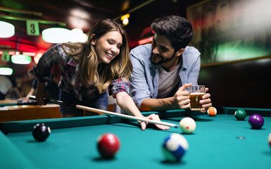 Couple dating, flirting and playing billiard in a pub