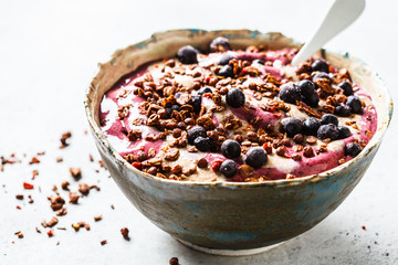 Berry smoothie bowl with peanut butter and granola. Healthy vegan food concept.
