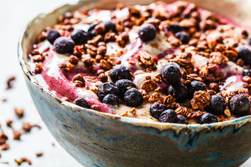 Berry smoothie bowl with peanut butter and granola. Healthy vegan food concept.