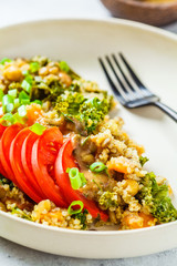 Vegan stew with chickpeas, sweet potato and fresh tomato on a white plate.