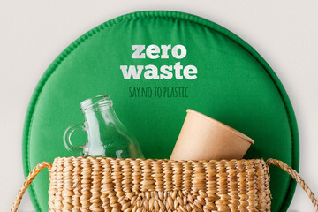 zero waste say no to plastic concept.top view wicker bag with glass bottle and reusable cup with...