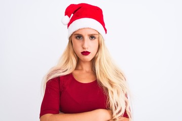 Young beautiful woman wearing Christmas Santa hat over isolated white background skeptic and nervous, disapproving expression on face with crossed arms. Negative person.