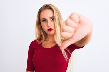 Young beautiful woman wearing red t-shirt standing over isolated white background with angry face,...