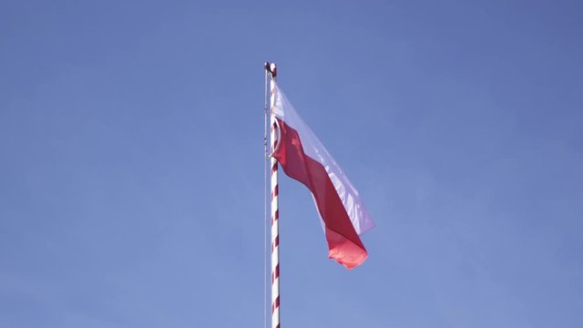 Flag of Poland. A Polish flag flutters on a high mast in slow motion from 100fps to 25 fps