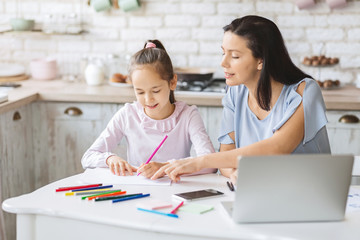 Little girl having lessons with tutor at home