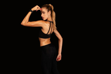 Fototapeta na wymiar Fit Girl Showing Arm Muscles Posing Over Black Background